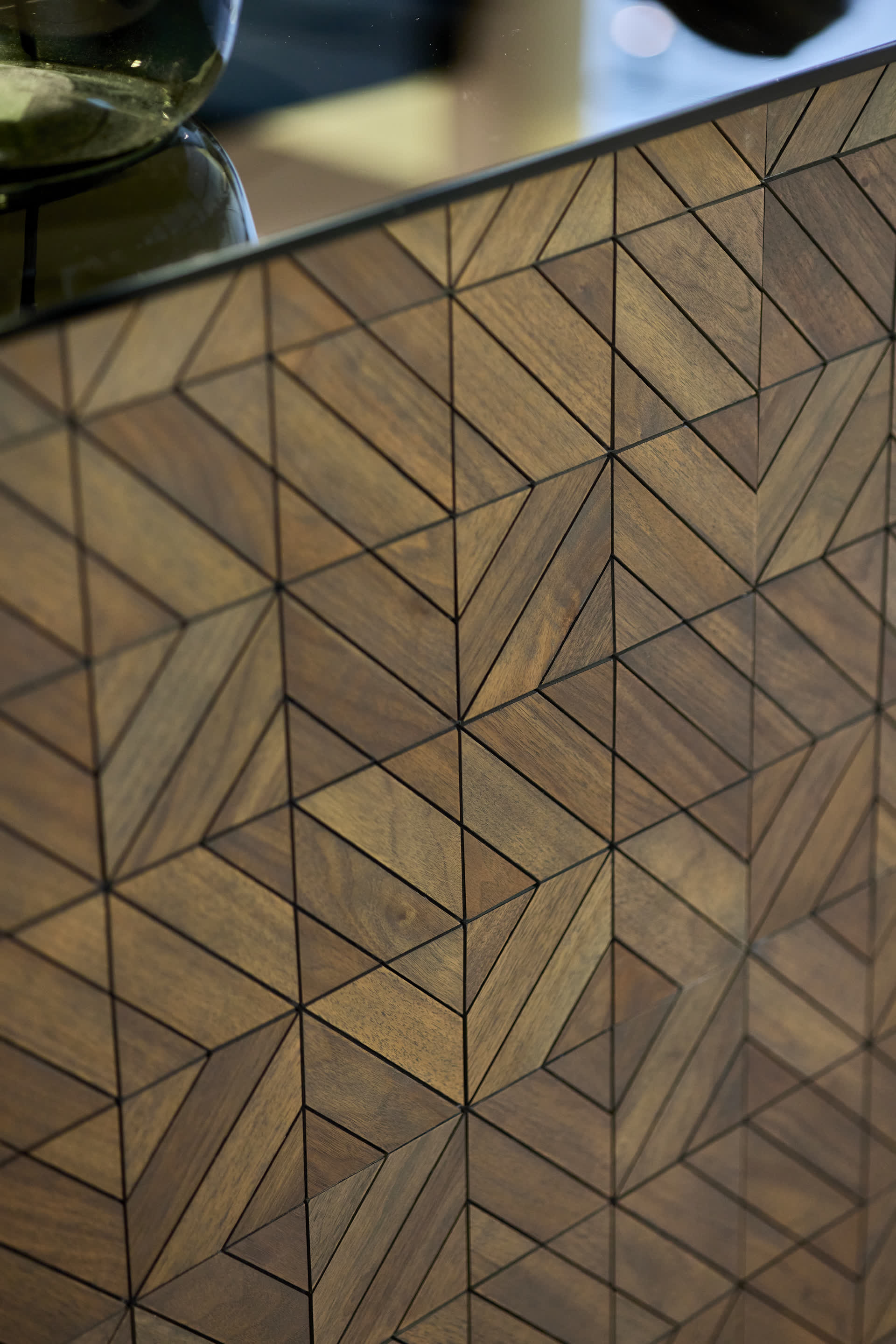 Die Empfangstheke aus der Nähe, mit geometrischer Holzverkleidung
